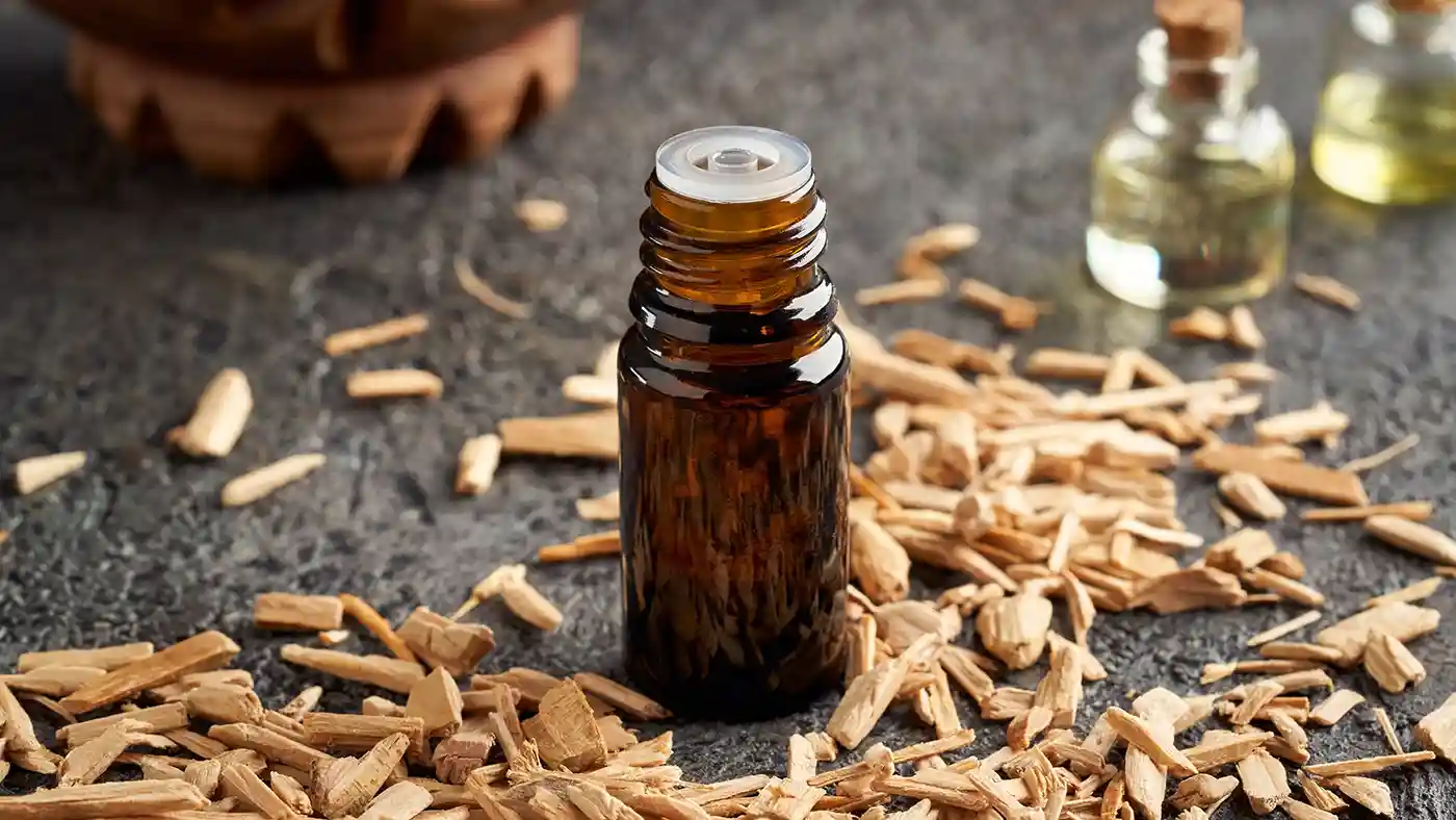 Cedarwood chips in front of amber glass bottle